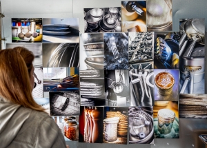 Artist Donna Dufault Looking at Wall of Images from the Culinary Imaginings series